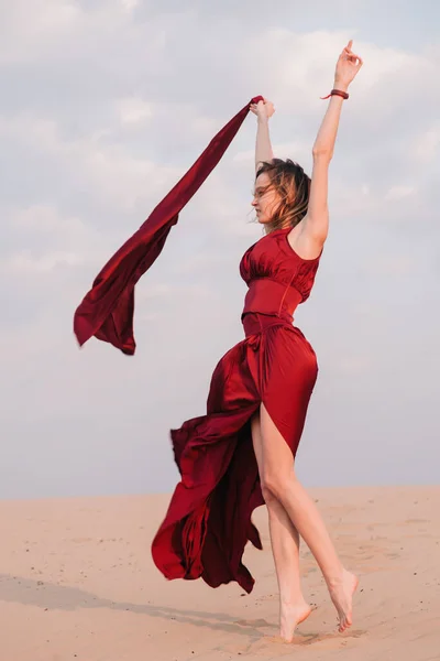 Menina em vestido vermelho ao pôr do sol no deserto — Fotografia de Stock