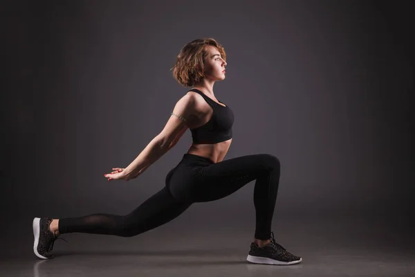 Chica joven haciendo yoga sobre un fondo negro — Foto de Stock