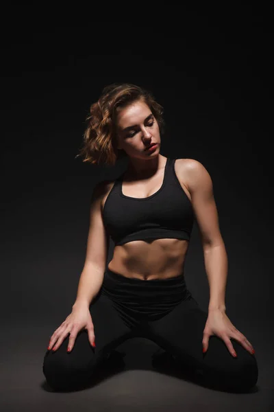 Young girl doing yoga on a black background — Stock Photo, Image