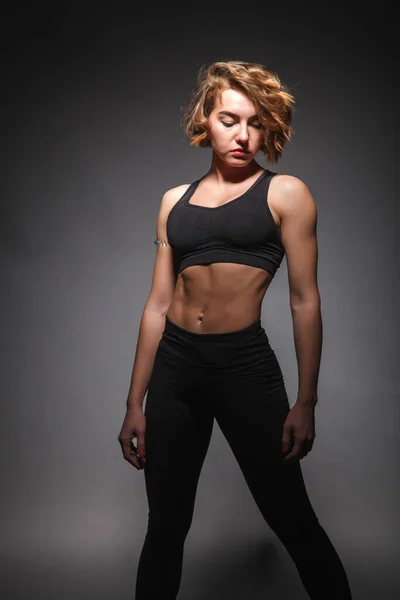 Chica joven haciendo yoga sobre un fondo negro — Foto de Stock