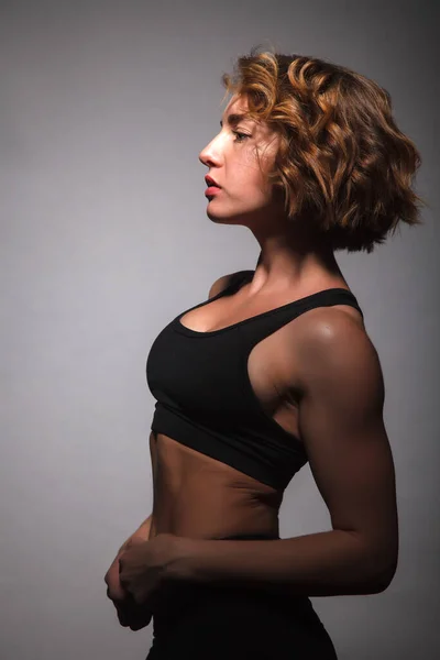 Chica joven haciendo yoga sobre un fondo negro — Foto de Stock