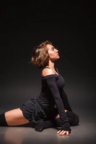 Jeune fille faisant du yoga sur un fond noir — Photo