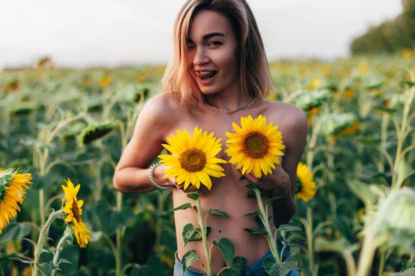 Una joven en topless se para en girasoles — Foto de Stock