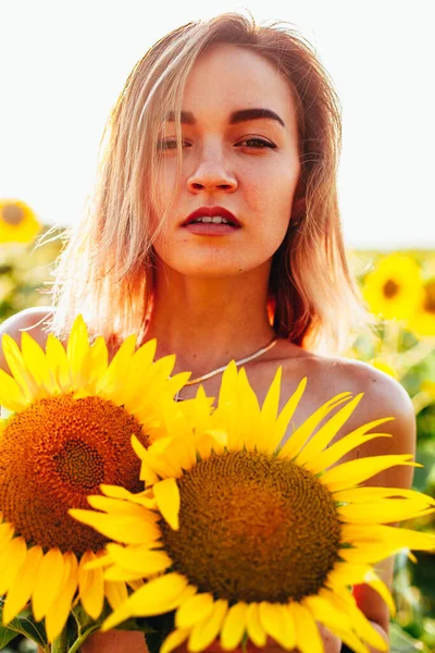 Молода топлес дівчина стоїть в соняшниках — стокове фото
