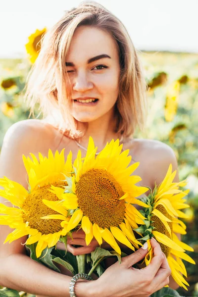 A young topless girl stands in sunflowers — Stock Photo, Image