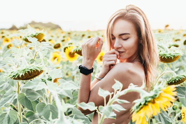 Una giovane ragazza in topless si trova in girasoli — Foto Stock