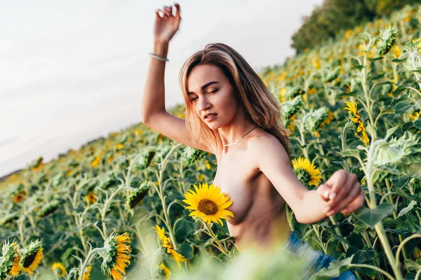 Una giovane ragazza in topless si trova in girasoli — Foto Stock