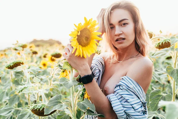 Una joven con camisa está de pie en girasoles — Foto de Stock