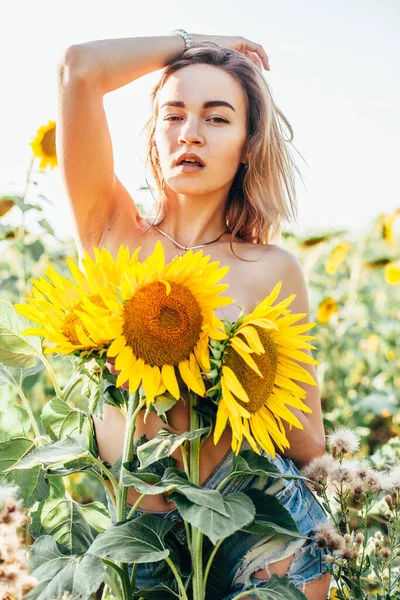 Una joven en topless se para en girasoles — Foto de Stock