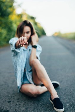 Pistte erkek gömleğiyle otostop yapan güzel kız.