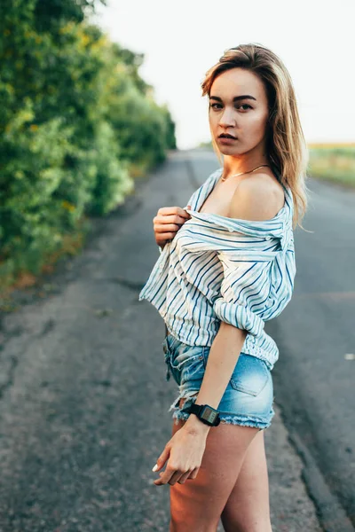 Piękna dziewczyna autostopem na torze w męskiej koszuli — Zdjęcie stockowe