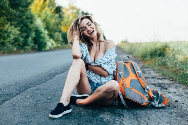 Pistte erkek gömleğiyle otostop yapan güzel kız.