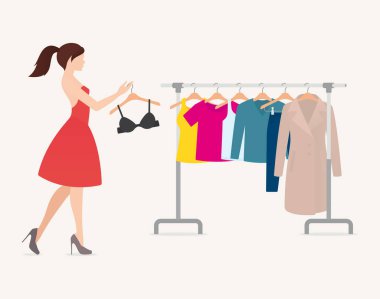 Güzel bir kadın ve asılmış renkli elbiseli bir askı. Beyaz arkaplanda izole.