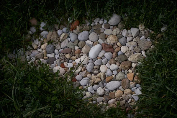 Pebbel stenen in het groene gras — Stockfoto