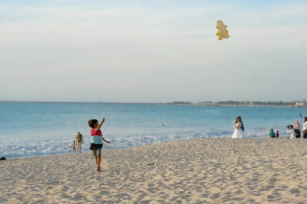 Jongen vliegen een vlieger op het kunstmatige strand op bali — Stockfoto