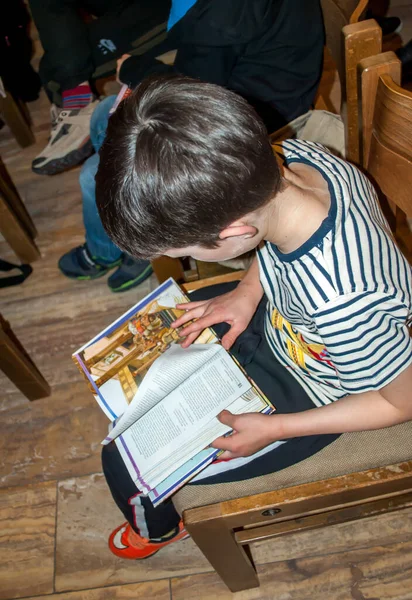 A fiú Bibliát olvas a gyerekek keresztény táborában. — Stock Fotó