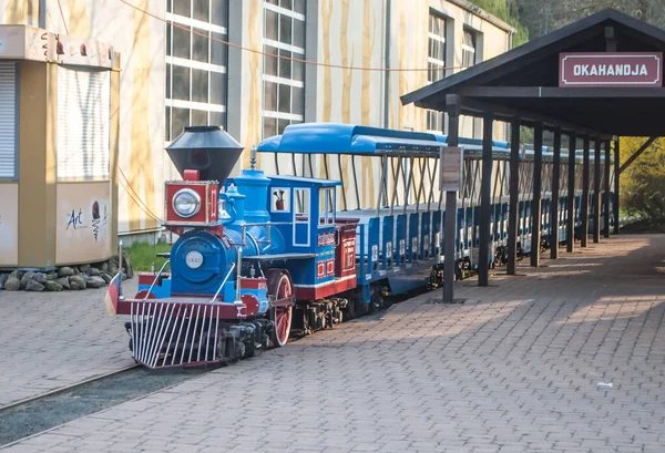 Ferrovia infantil no zoológico, uma locomotiva a vapor e carros azuis em pé na estação na plataforma — Fotografia de Stock