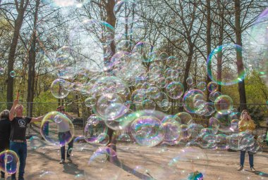 Berlin, Almanya - 6 Nisan 2019: Bir insanın Berlin 'de, Reichstag yakınlarında bir sokakta parka girmesine izin verdiği bir sürü büyük sabun köpüğü. Şehri ziyaret eden pek çok turist çekiyor..