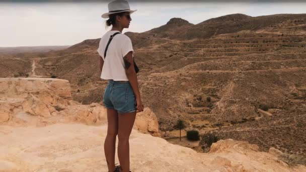 一人で山の丘 山の少女の幻想的なショット ヒルズ砂漠はただ見ています アフリカ チュニジアのすばらしい自然 — ストック動画