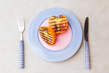 Gri arka plan üzerinde ızgara persimmones