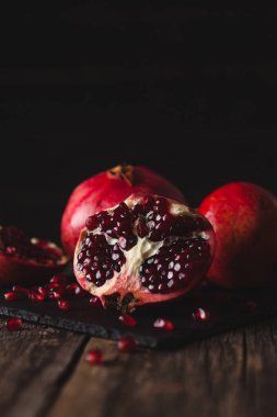 Nar meyve karanlık tahtada yatıyor.