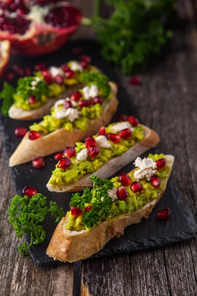Avokado ve nar ahşap masa üzerinde tost