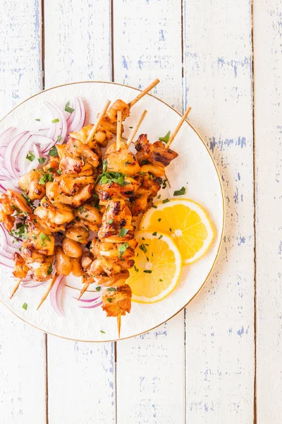 Kebab de pollo con limón y cebolla sobre fondo de madera . — Foto de Stock