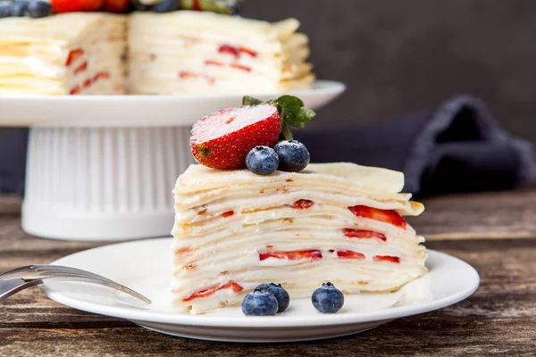 Crepe cake bakery piece with strawberry and vanilla sauce on woo