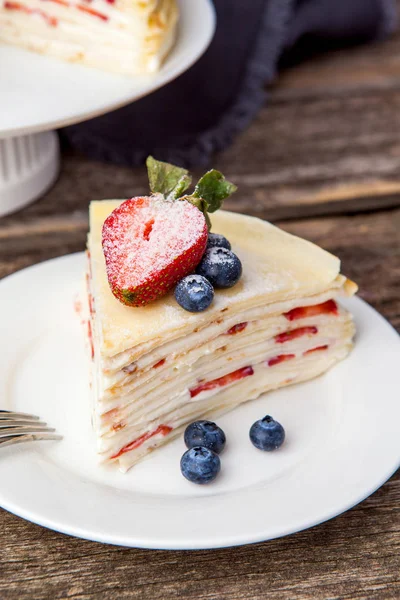 Crepe cake bakery piece with strawberry and vanilla sauce on woo