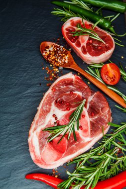 Biftek bonewith kiraz domates, acı biber ve otlar. Ham sığır eti biftek baharat ve biberiye ile.