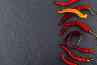 Siyah arka planda kırmızı sıcak Chili Peppers. Metin için boş alan. Üst görünüm