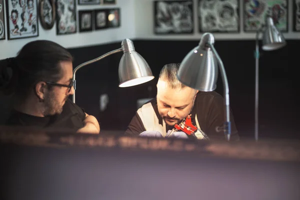 Guy is making tattoo, in a studio. — Stock Photo, Image