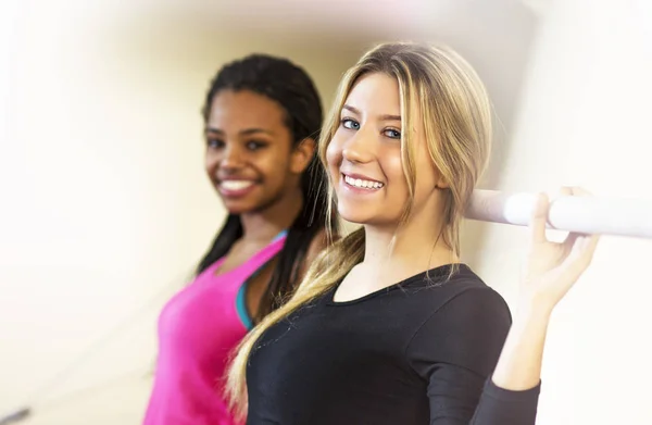 Twee sport meisjes genieten van tijd in een sportschool. — Stockfoto