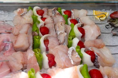 Çiğ taze balık fileto kebabı ve buzlukta sebzeler. Yunan pazarında buzdaki deniz ürünleri.
