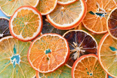 Limon, mandalina, portakallar ve mavi arka plandaki birçok susuz narenciye meyvesinin üst görüntüsü. Kurutulmuş narenciye dilimleri..