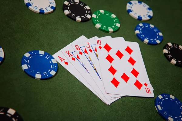 Ace, King, Queen, Jack, Ten, diamonds lie on poker chips close-up, flash royal