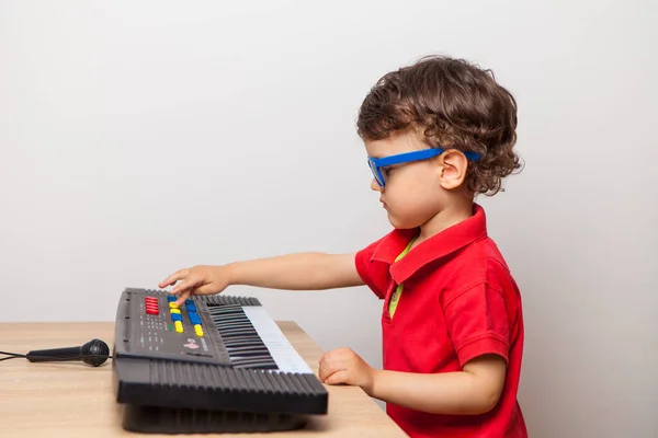 the child arranges a concert at home for parents playing the synthesizer. Imagine the street and the scene in sunglasses. dull and funny quarantine at home