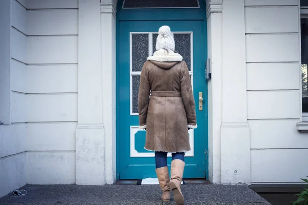 Mujer joven de pie - ir a la puerta de entrada exterior . Imágenes De Stock Sin Royalties Gratis