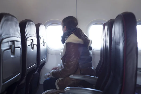 Vrouw is op passagiersstoel op vliegtuig — Stockfoto
