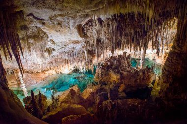 İspanya 'da Mallorca adasındaki Stalactite aydınlatmalı mağaralar. Mağaraların çok renkli aydınlatması. Güzel mağara. Eski mağaradaki sarkıtlar. Kırmızı, yeşil, mavi, mor, sarı