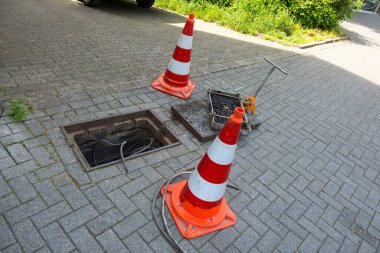 Sorun çözmede ya da kamu hizmetinde tamirat. İçinde kablo olan demir kapağı aç