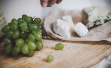 Üzüm ve beyaz şarap ile öğle yemeği için peynir tabağı yatak odasında. 