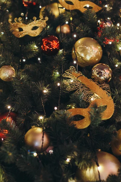 Icicle'ı ışıklar diğer kırmızı ve sarı parlak baubles ile Noel ağacı üzerinde bir Noel ağacı oyuncak gibi altın karnaval maskesi