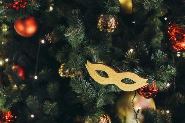 Icicle'ı ışıklar diğer kırmızı ve sarı parlak baubles ile Noel ağacı üzerinde bir Noel ağacı oyuncak gibi altın karnaval maskesi