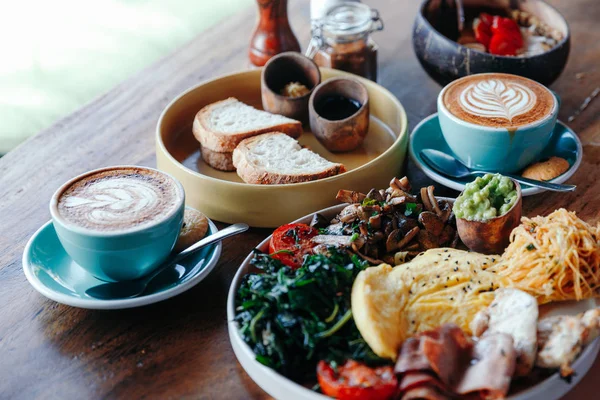Masada sabah kahvaltısı, kremalı waffle, krema, kahve, kapuçino, kase, sebzeli omlet, tereyağlı ekmek, avokado kreması, vejetaryen yemeği, sağlıklı yemek.
