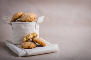 Bej arka planda keten sepetinde ev yapımı bisküviler. çatlak kurabiyeler