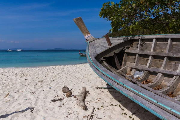 A broken boat stands on the sand. Boat by the sea. Fishing boat washed ashore