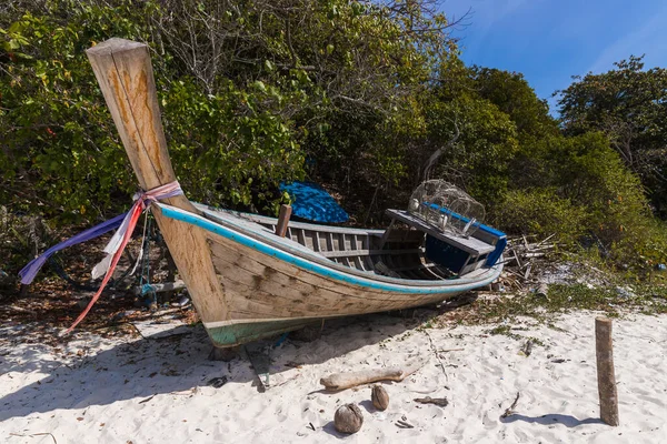 A broken boat stands on the sand. Boat by the sea. Fishing boat washed ashore