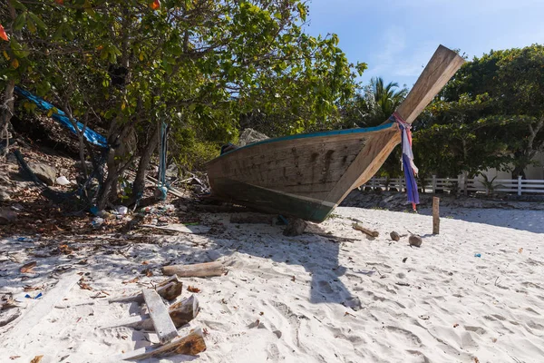 A broken boat stands on the sand. Boat by the sea. Fishing boat washed ashore