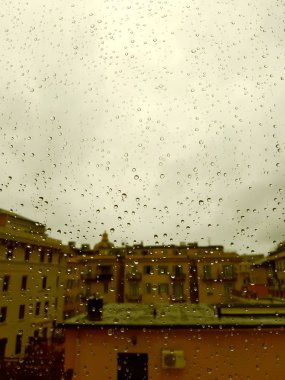 Cenova, İtalya - 11 / 28 / 2019: İnanılmaz renkli bir gökyüzü ve bir parça güneş ışığı ile çok şiddetli bir yağmurdan sonra pencerenin üzerindeki su damlasının inanılmaz bir başlığı. Takasın makro fotoğrafçılığı.